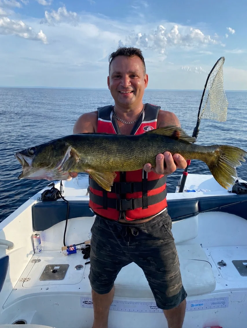 Pêcheur souriant présentant un doré sur le lac