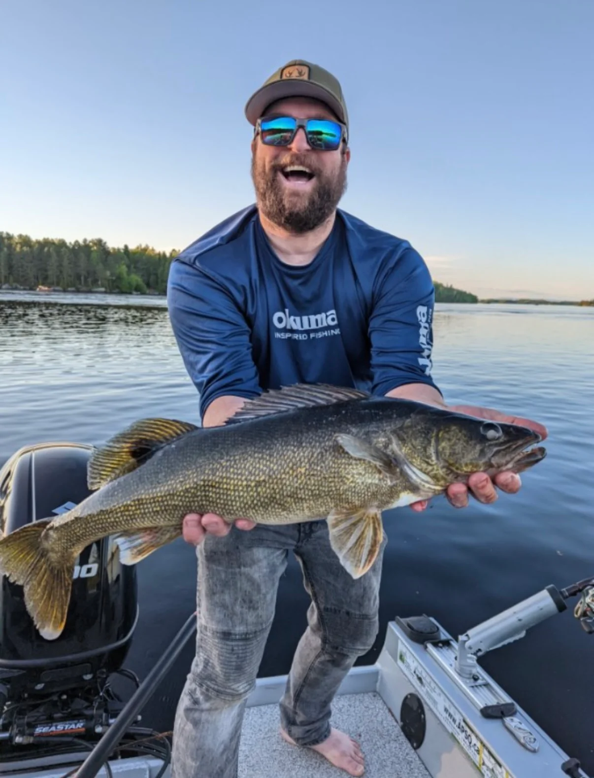 Pêcheur souriant présentant un doré sur le lac